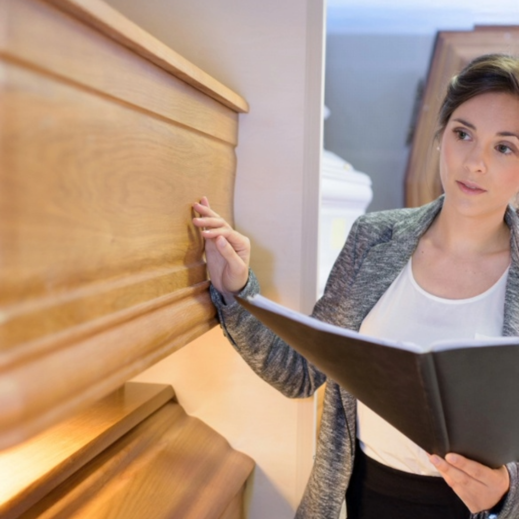 Woman inspecting casket for sale.
